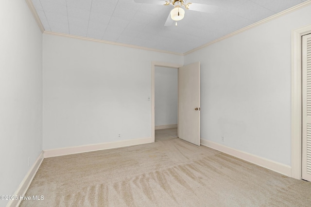 empty room with ceiling fan, light carpet, and crown molding