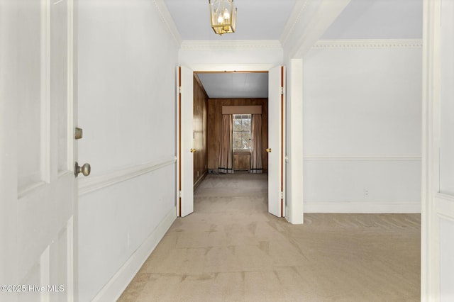 hall featuring light carpet, crown molding, and wooden walls