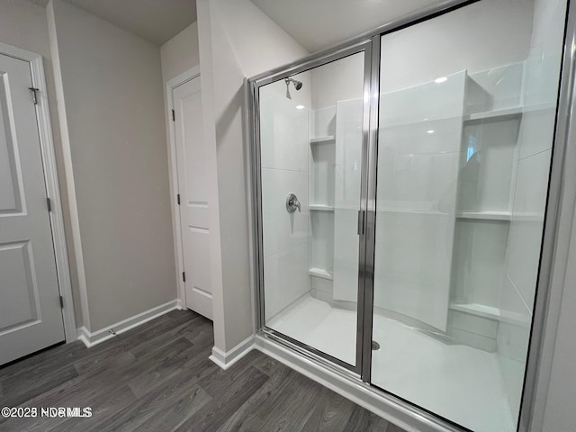 bathroom featuring hardwood / wood-style floors and a shower with door