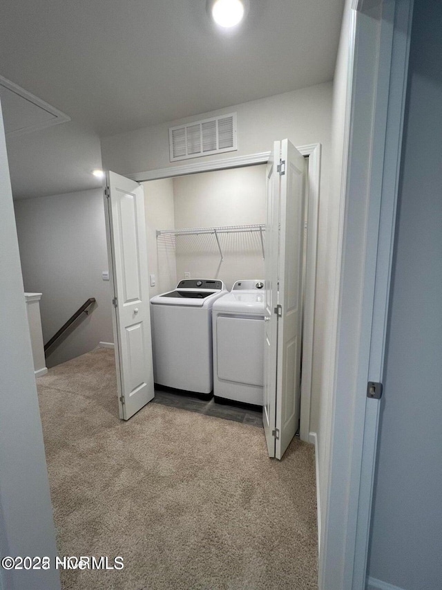 washroom featuring light colored carpet and washer and clothes dryer