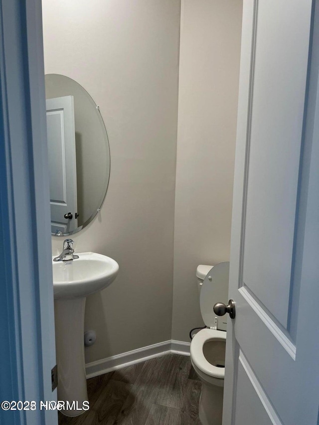 bathroom featuring hardwood / wood-style flooring and toilet