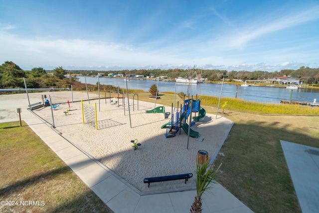 view of property's community featuring playground community, a water view, and a lawn