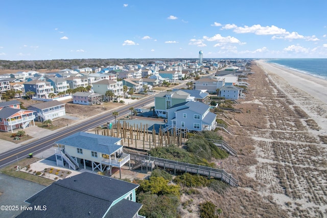 drone / aerial view with a residential view, a water view, and a beach view