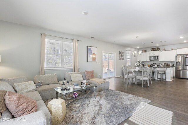 living room featuring dark wood-type flooring and a notable chandelier