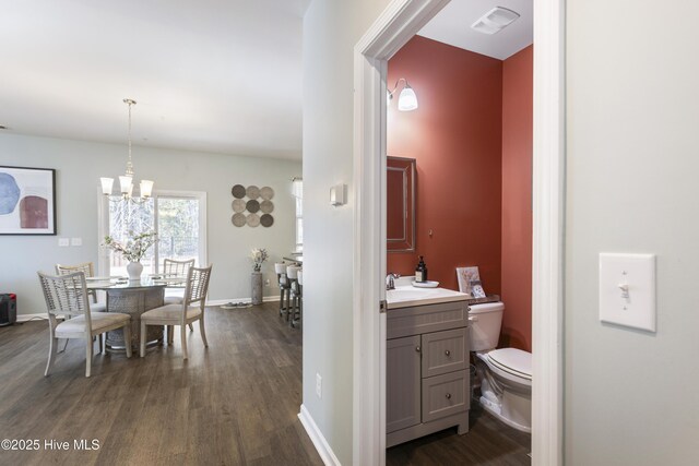 dining space featuring dark hardwood / wood-style flooring and a chandelier