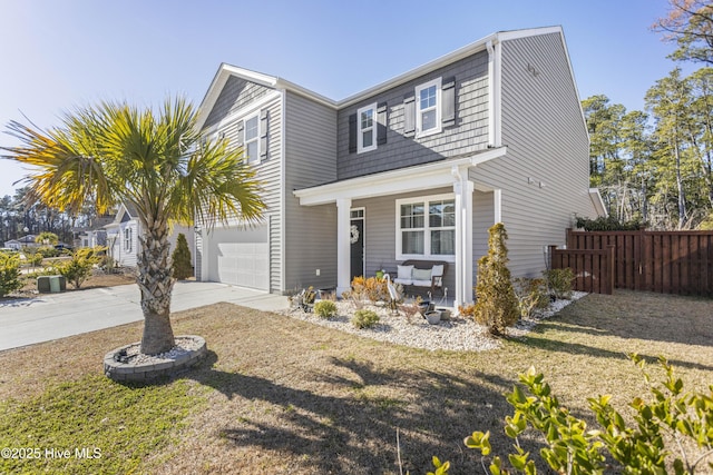 view of front of home with covered porch, fence, a garage, and driveway