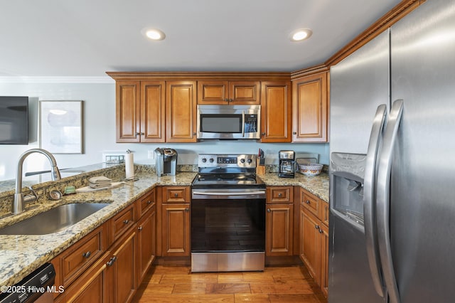 kitchen with appliances with stainless steel finishes, light hardwood / wood-style floors, sink, light stone counters, and crown molding