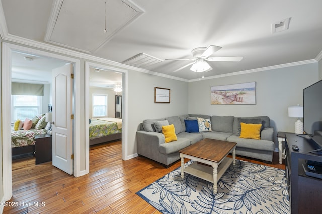 living room with ceiling fan, crown molding, and wood-type flooring