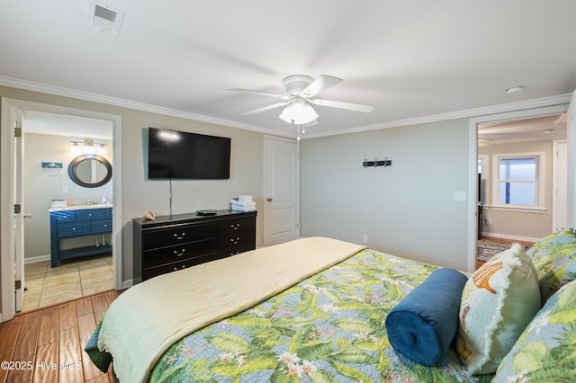 bedroom featuring ceiling fan, connected bathroom, light hardwood / wood-style flooring, and crown molding