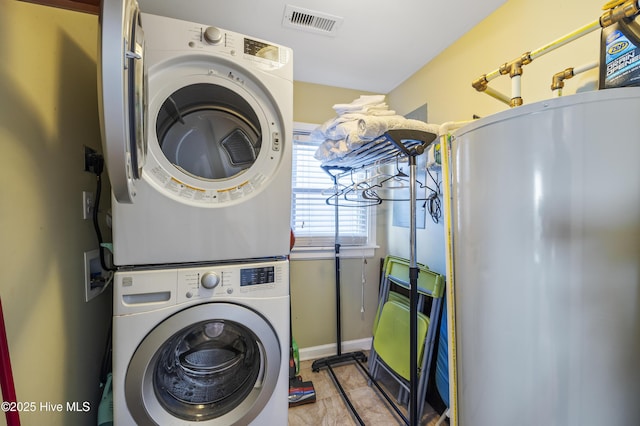 clothes washing area with stacked washer and clothes dryer and water heater