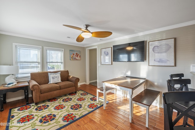 living room with light wood-type flooring, ceiling fan, and ornamental molding