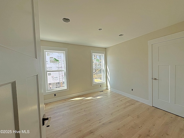 unfurnished room featuring light wood-type flooring and baseboards