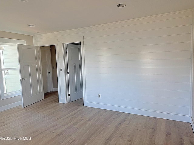 unfurnished bedroom with baseboards and light wood-style floors