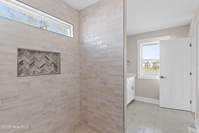 bathroom with baseboards and a tile shower