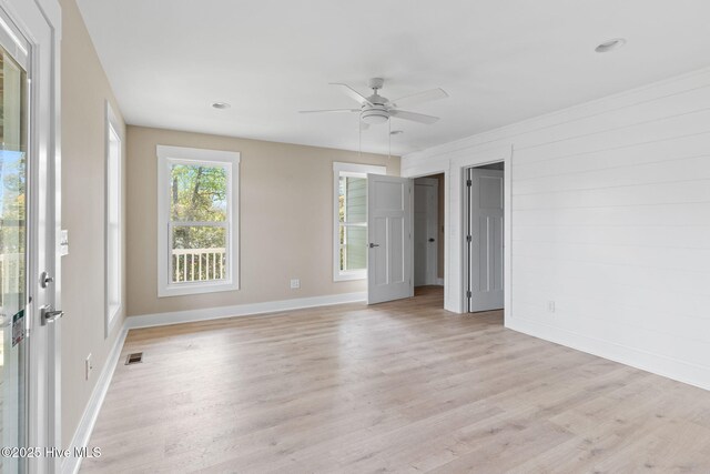 unfurnished bedroom featuring baseboards, visible vents, ceiling fan, and light wood finished floors