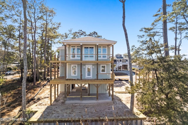 back of property featuring a shingled roof and a balcony