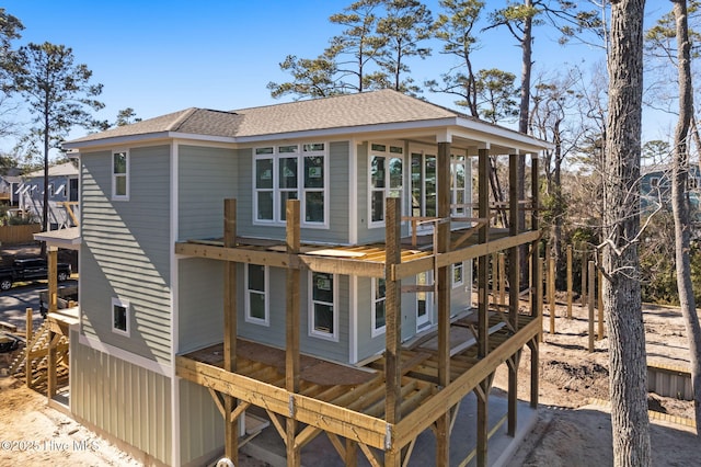 rear view of property featuring roof with shingles