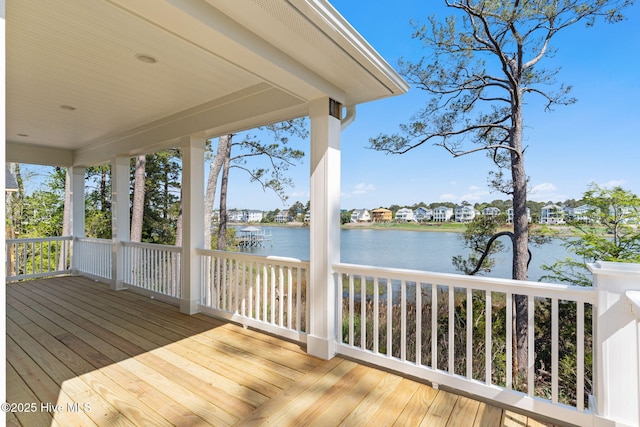 wooden deck with a residential view and a water view