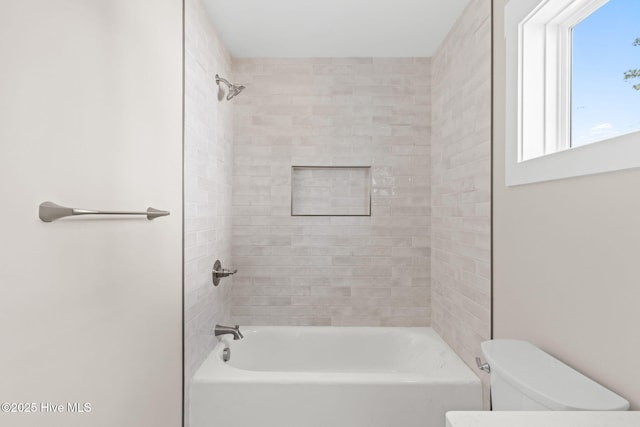bathroom featuring bathtub / shower combination and toilet