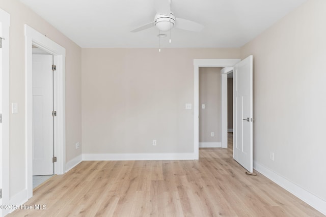 spare room featuring baseboards, a ceiling fan, and light wood-style flooring