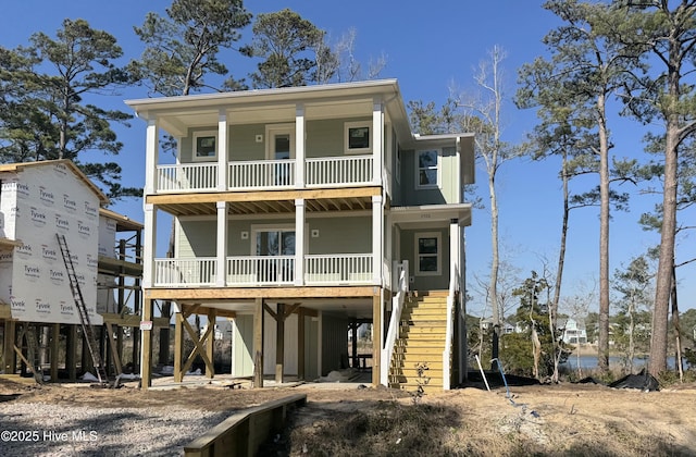 coastal home featuring a porch, stairway, board and batten siding, a carport, and driveway