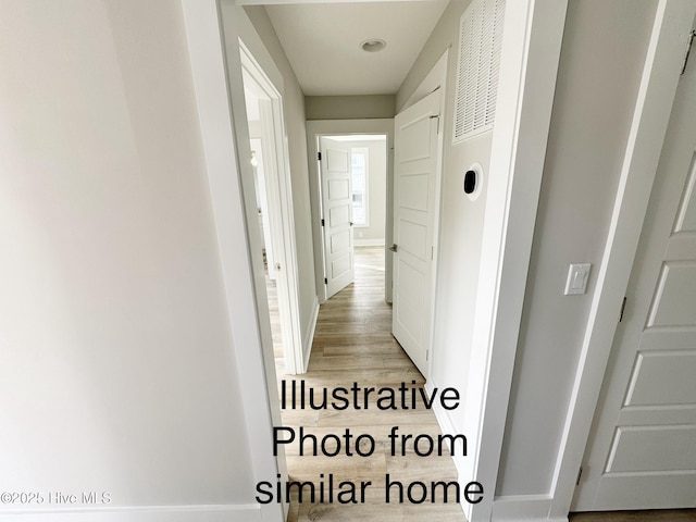 hallway with light wood-style flooring and baseboards