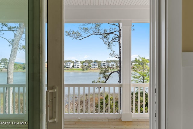 entryway with a water view, a residential view, and wood finished floors