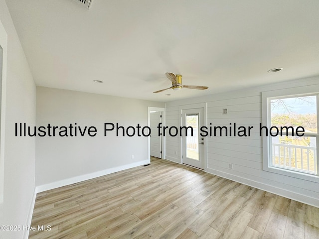 unfurnished room featuring a ceiling fan, baseboards, and light wood finished floors