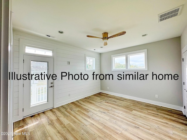 unfurnished room with light wood-style flooring, a ceiling fan, visible vents, and baseboards