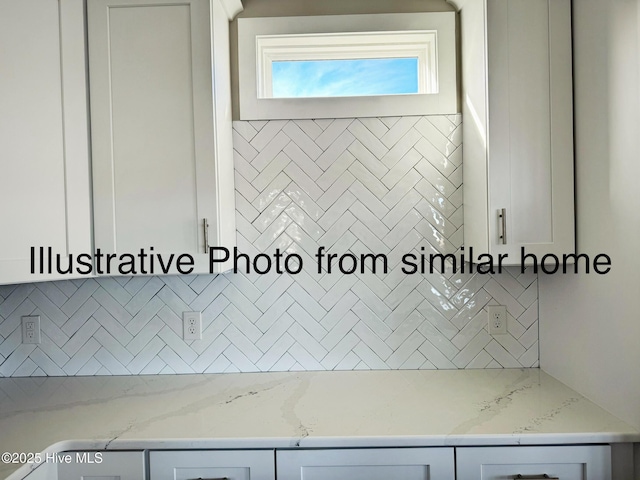 interior details featuring backsplash and light stone countertops