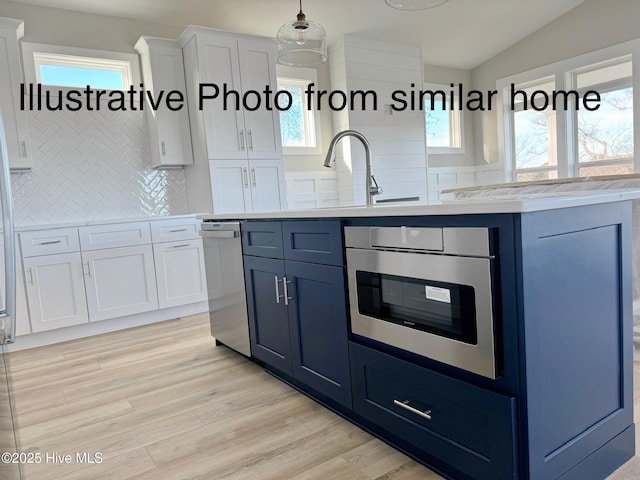 kitchen with blue cabinetry, white cabinets, and light countertops