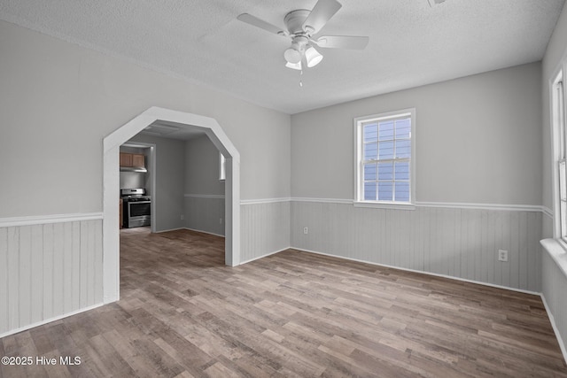 additional living space with ceiling fan, light wood-type flooring, and a textured ceiling