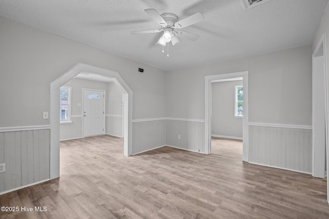 additional living space with light wood-type flooring, ceiling fan, and a textured ceiling