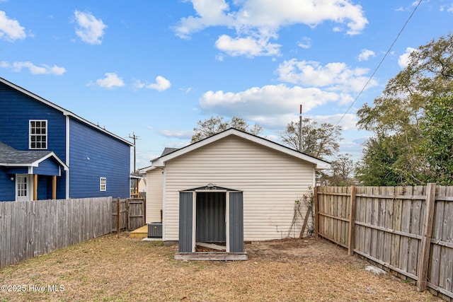 back of house featuring a storage unit