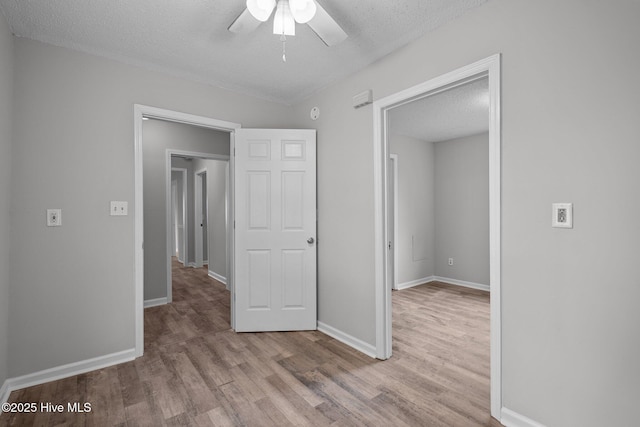 unfurnished bedroom with a textured ceiling, ceiling fan, and light hardwood / wood-style flooring