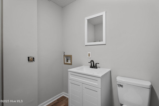 bathroom featuring toilet, vanity, and hardwood / wood-style floors