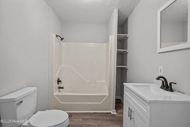 full bathroom featuring toilet, hardwood / wood-style floors, shower / bathing tub combination, a textured ceiling, and vanity