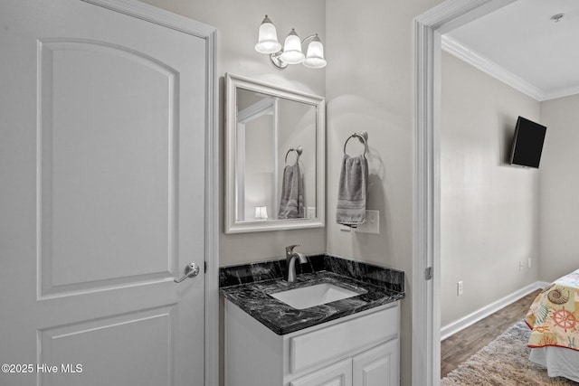 bathroom featuring crown molding, hardwood / wood-style floors, and vanity