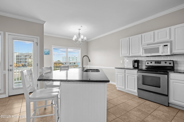 kitchen featuring stainless steel electric range oven, sink, backsplash, hanging light fixtures, and a kitchen island with sink