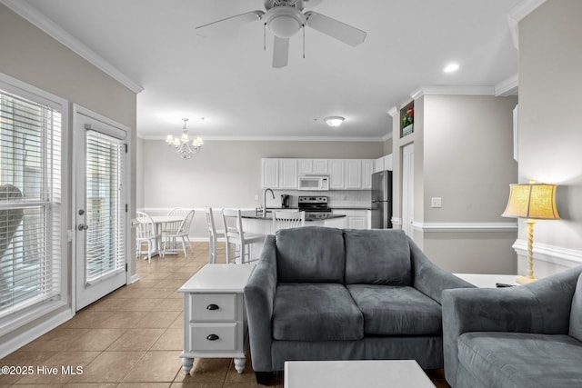 living room featuring sink, crown molding, ceiling fan with notable chandelier, and light tile patterned flooring