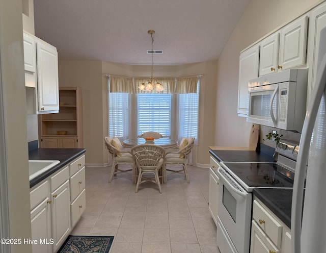 kitchen with electric stove, light tile patterned floors, white cabinetry, hanging light fixtures, and a chandelier