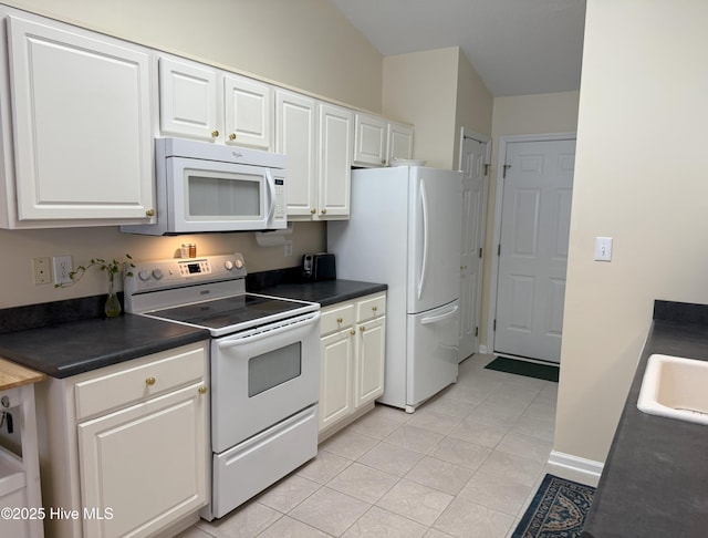 kitchen with sink, white appliances, white cabinets, and light tile patterned flooring