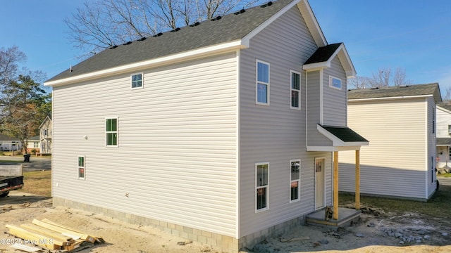 view of property exterior with a shingled roof