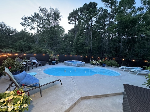 view of pool featuring an in ground hot tub and a patio