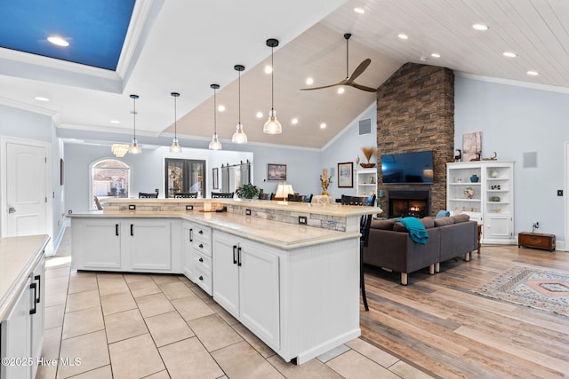 kitchen featuring white cabinetry, a large island, decorative light fixtures, and a breakfast bar