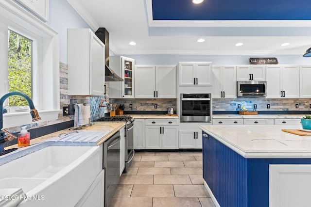 kitchen featuring white cabinetry, ornamental molding, appliances with stainless steel finishes, and sink