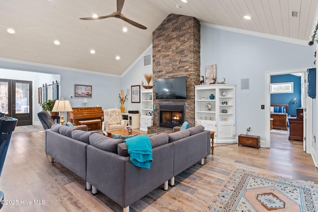 living room featuring french doors, ornamental molding, a fireplace, and light hardwood / wood-style floors