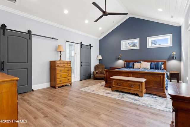 bedroom with a barn door, vaulted ceiling, multiple windows, and light hardwood / wood-style flooring