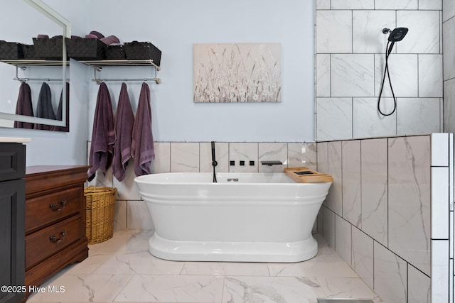 bathroom featuring vanity, tile walls, and a tub to relax in