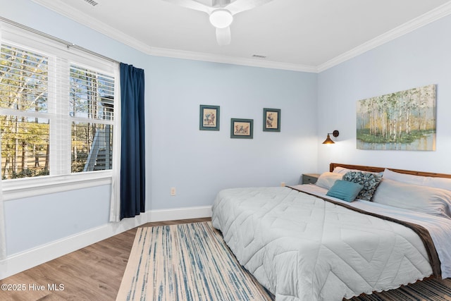 bedroom with ceiling fan, ornamental molding, and wood-type flooring